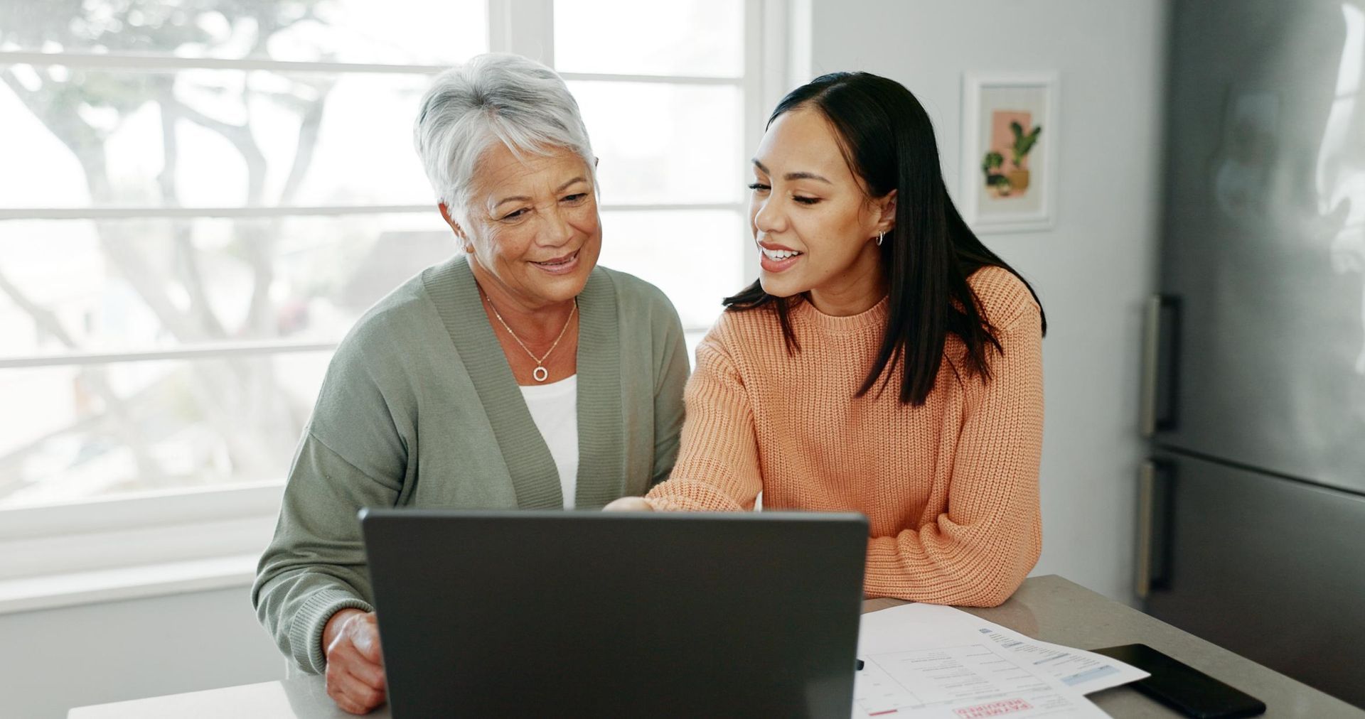Two women reviewing information at a table